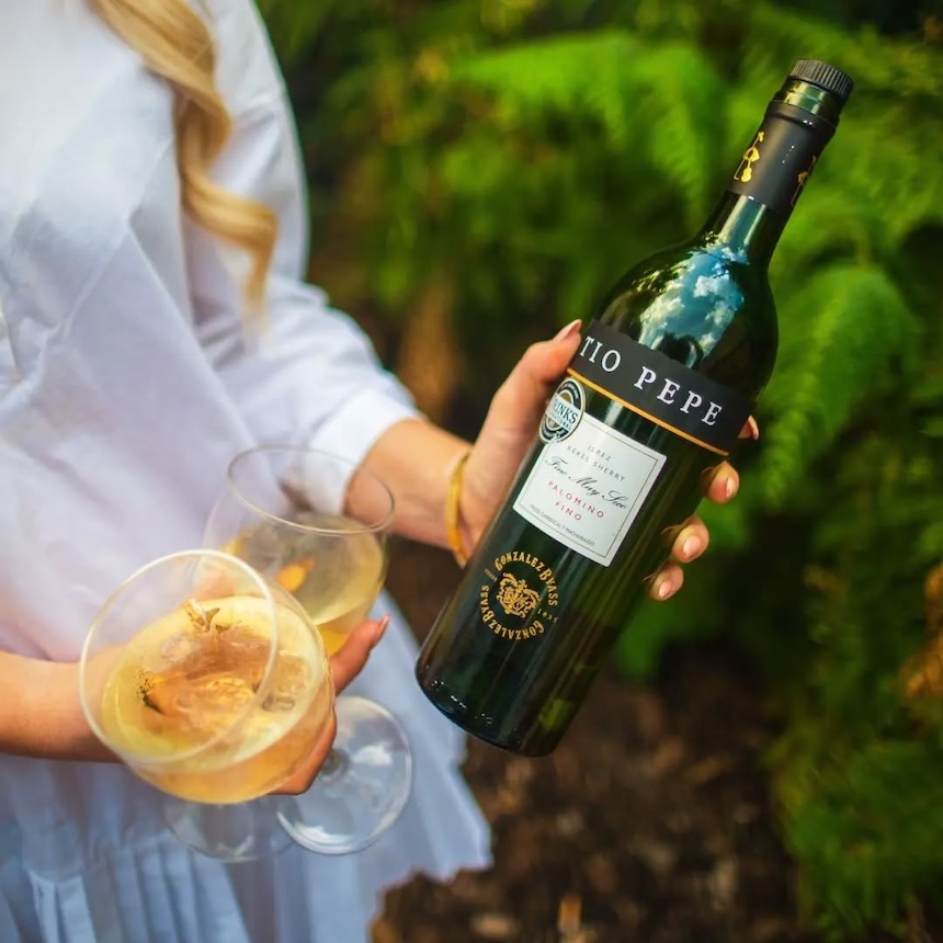 Tío Pepe sherrypullo kädessä, toisessa kädessä sherrylasit