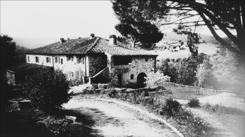 Mustavalkoinen kuva idyllisestä isosta kivitalosta Italian maaseudulla