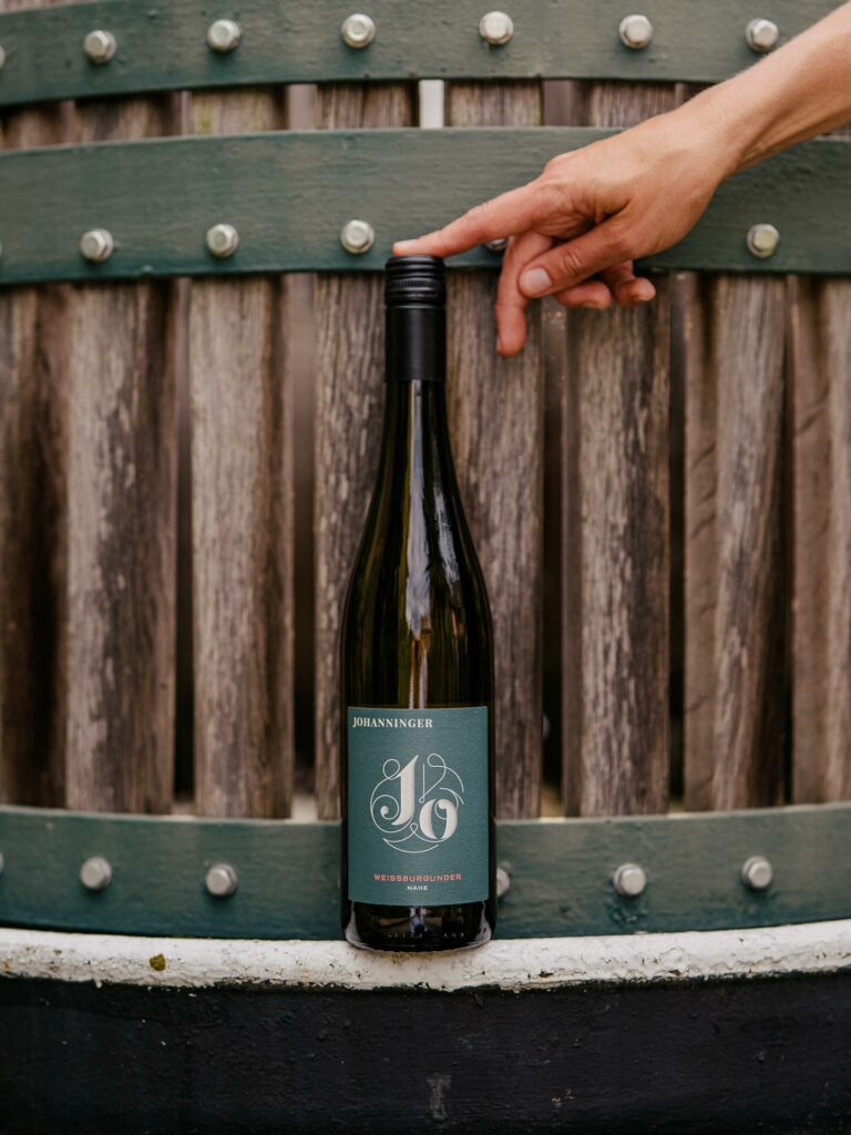 Johanningerin viinipullo kuvattuna samansävyisen tynnyrin edessä