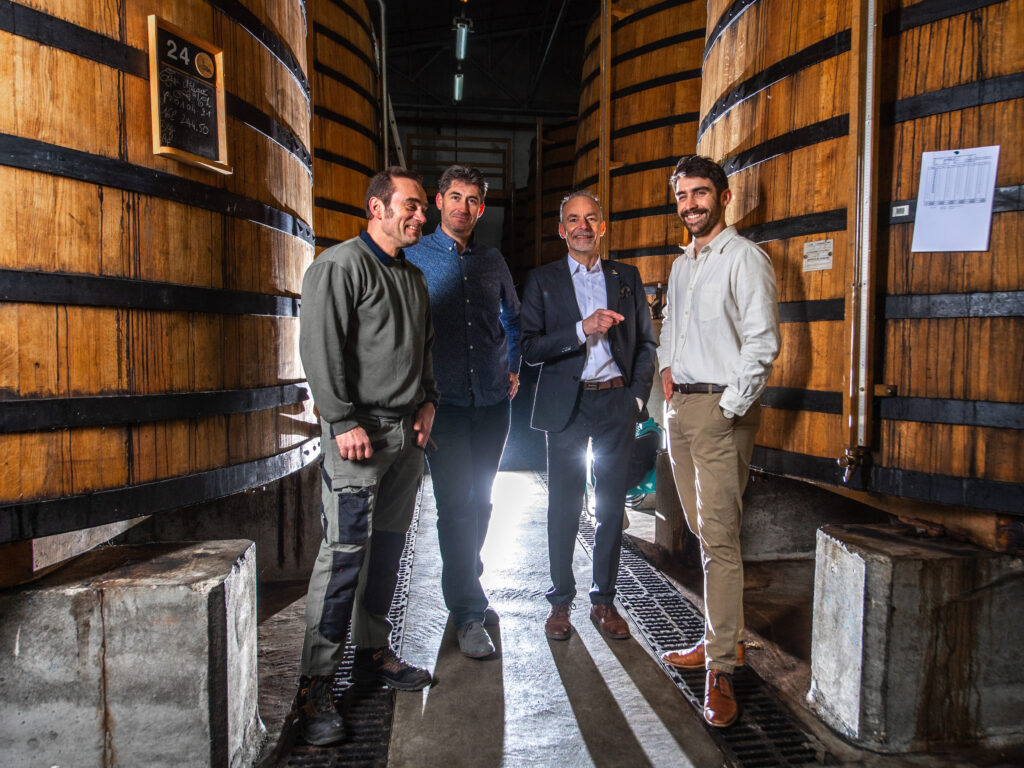 Hinen neljän hengen Eaux-de-vie-tiimi isojen tynnyreiden keskellä.