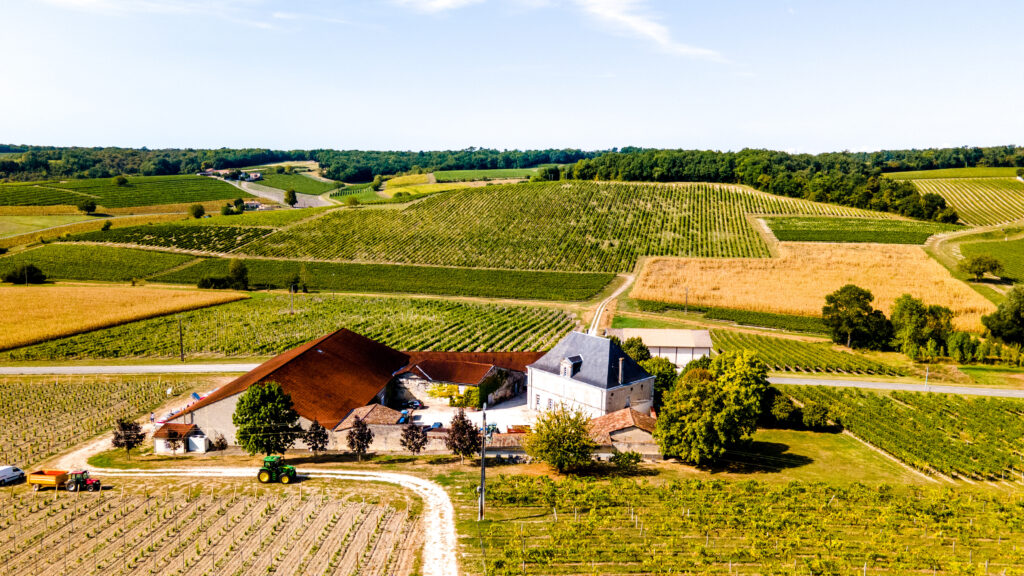 Ilmakuva Cognacista, jossa näkyy tila vehreiden viinipeltojen ympäröimänä.